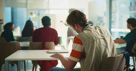 Student, man and back in classroom at university with learning, notes and listen for education....