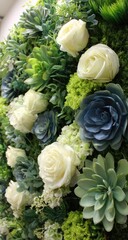 Arrangement of succulents, roses, and greenery.