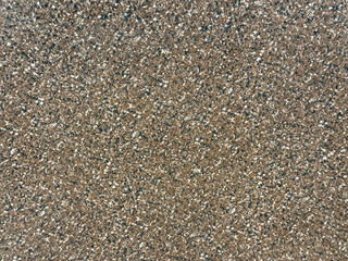 Close up of brown terrazzo granite stone with black and white dots pattern. Dark brown granite stone seamless background texture.