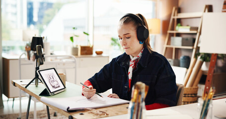 Drawing, tablet and headphones with woman in studio for art reference, illustration or sketch pad. Streaming, talent and inspiration with person and notebook in workshop for artist and creative hobby