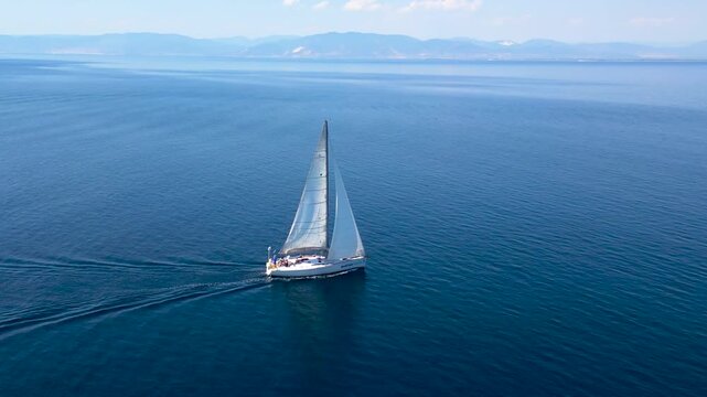A sailboat sails the sea around the island of Thassos video footage taken by a drone