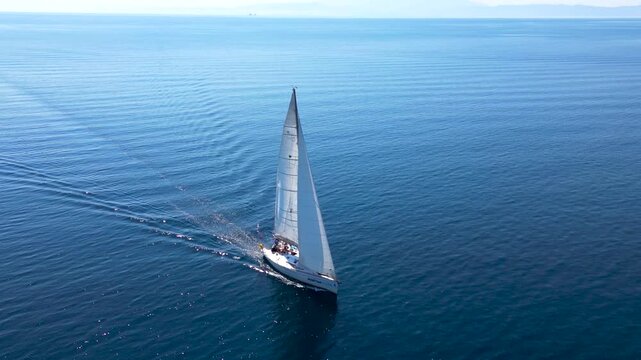 A sailboat sails the sea around the island of Thassos video footage taken by a drone