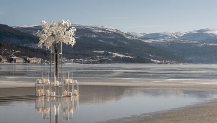Elegant floral display with candles on a frozen lake.