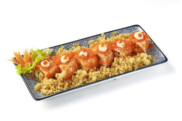 Plate of sushi rolls topped with orange fish roe, mayonnaise, and surrounded by crispy tempura flakes, garnished with fresh lettuce and carved carrot for decoration