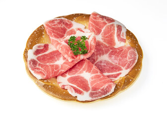 Thinly sliced marbled pork arranged on wooden plate, garnished with fresh parsley, showcasing its vibrant pink color and rich texture, perfect for grilling or hot pot dishes