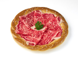 Thinly sliced marbled beef arranged on decorative plate with garnish of fresh parsley, showcasing its rich texture and vibrant red color