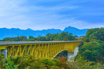 秋の山梨県北杜市の八ヶ岳高原大橋(黄色い橋)と南アルプスの眺望