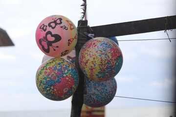 Colorful Bouncy Balls Decorated with Butterflies and Splattered Paint Hanging Outdoors
