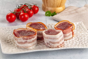 Raw pork tenferloin with bacon