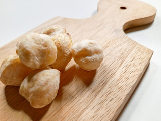 Candlenuts on Wooden Cutting Board with Dark Grey Background