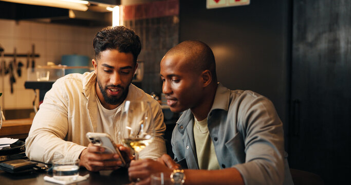 Alcohol, friends and men with phone in restaurant for social media, online message and conversation. Nightclub, talking and people with wine, drinks and smartphone for reunion, hangout and weekend