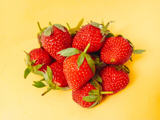 Fresh red strawberries isolated on a yellow background.