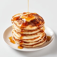 A stack of pancakes with syrup being poured on top