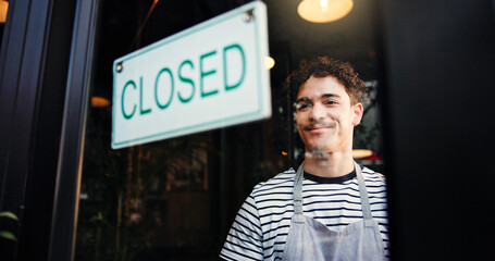 Man, waiter and closed sign on cafe door for end of day, no service and message to customer. Smile,...