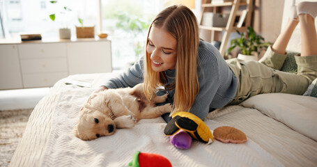 Happy, playing and woman with puppy on bed for learning, development and bonding after adoption....