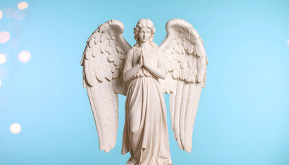 Elegant Praying Angel Statue Against a Light Blue Background