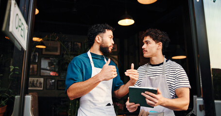Tablet, conversation and people in cafe, employees and hospitality with help, menu items or...