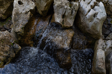 A peaceful scene of stone formations surrounded by greenery and water, creating a serene atmosphere...