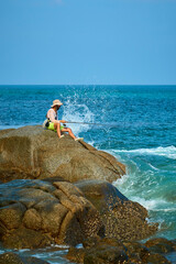 a man is fishing on the rocks by the sea