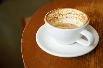 Empty cup of hot milk latte coffee on table by the window.