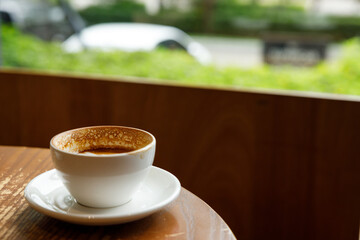 Empty cup of hot milk latte coffee on table by the window.