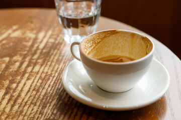 Empty cup of hot milk latte coffee on table by the window.
