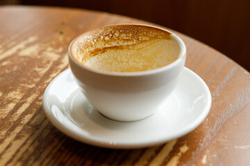 Empty cup of hot milk latte coffee on table by the window.