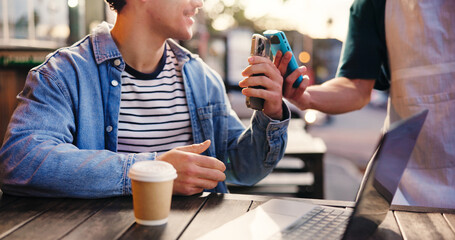 Pos machine, waiter and man with cellphone, ecommerce and payment with wireless transaction. Coffee...