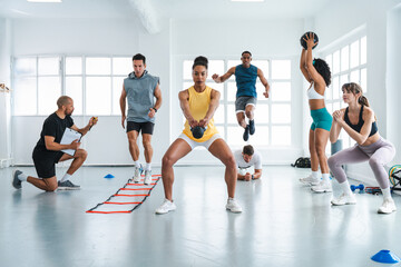 Multiethnic group of sportive people doing functional workout at the gym, concepts about sport and...