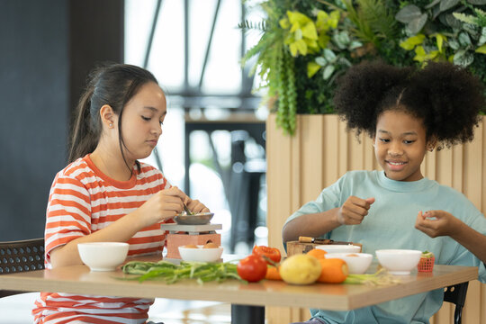 group of multi-ethnic children girls are learning how to cooking with miniature kitchen utensils, teamwork student education up skill make food.