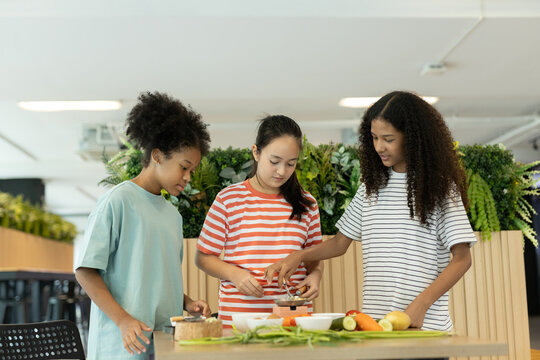 group of multi-ethnic children girls are learning how to cooking with miniature kitchen utensils, teamwork student education up skill make food. - Powered by Adobe