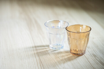 Two plastic cups on wooden floor
