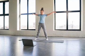 Child engaged in an online workout session in a bright room