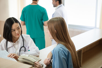 Asia doctor woman working and talking with Caucasian woman medical student at hospital	