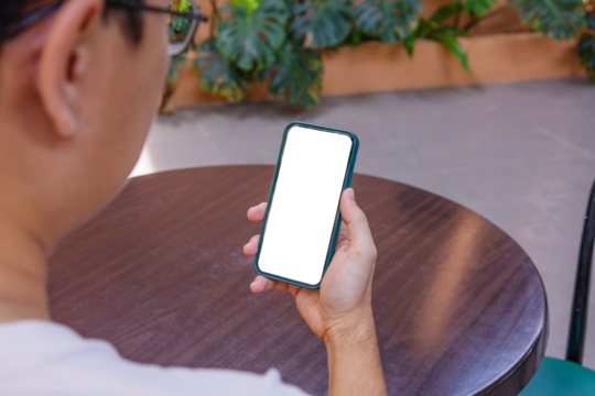 Man holding phone blank screen in coffee shop or restaurant. Phone mockup