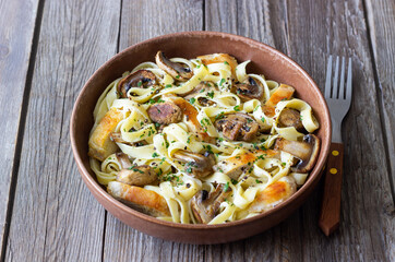 Fettuccine pasta with chicken and mushrooms in creamy sauce. Italian cuisine. Recipe.