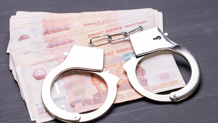 handcuffs and Russian five thousandth bills close -up, corruption concept, fraudulent and crime.