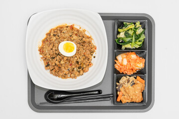 A Thai basil minced pork set meal arranged on a tray, including a portion of stir-fried spicy basil...