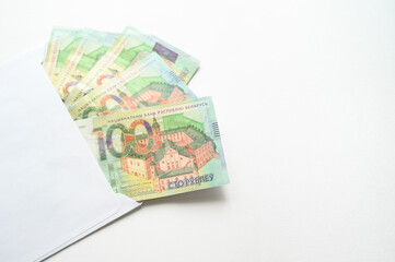Belarusian 100 ruble banknotes neatly placed inside white envelope on a clean white background. Symbolizing savings, financial gifts, or cash payments. Perfect for finance and banking projects.