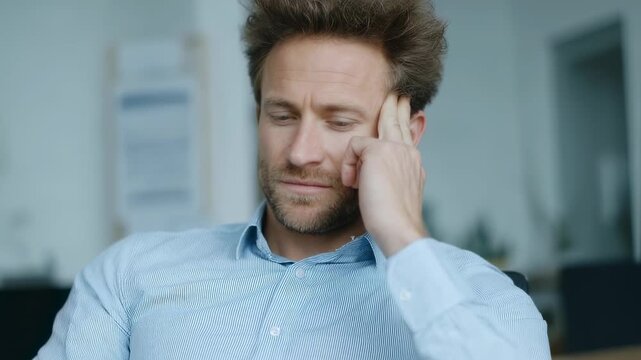 Caucasian man experiencing headache or stress in office. Mental health and workplace pressure concept. Migraine, tension, or burnout visualization for health awareness - Powered by Adobe