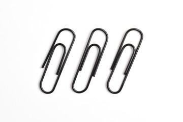 Three black paper clips isolated on white background