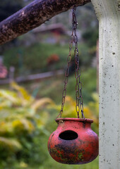 Hanging pots in a garden for birds to drink water.