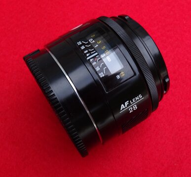 Minolta 28mm af lens resting on red background