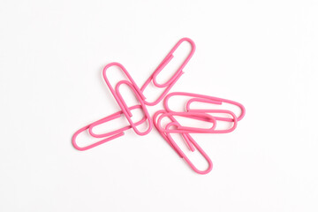 Many pink paper clips isolated on white background