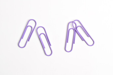 Purple paper clips isolated on white background