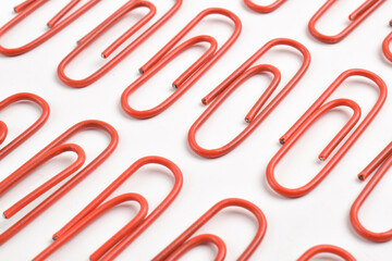 Many red paper clips isolated on white background, flat lay