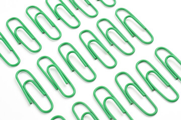 Many green paper clips isolated on white background, flat lay