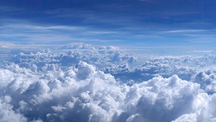 High-altitude view of a vast expanse of puffy white clouds against a vibrant blue sky