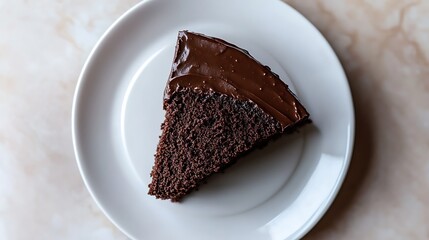 A slice of chocolate cake with glossy frosting on a white plate