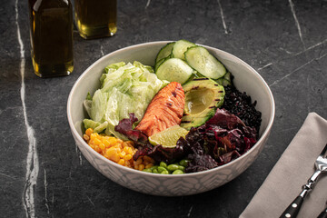 Healthy poke bowl with salmon, avocado, cucumber and vegetables